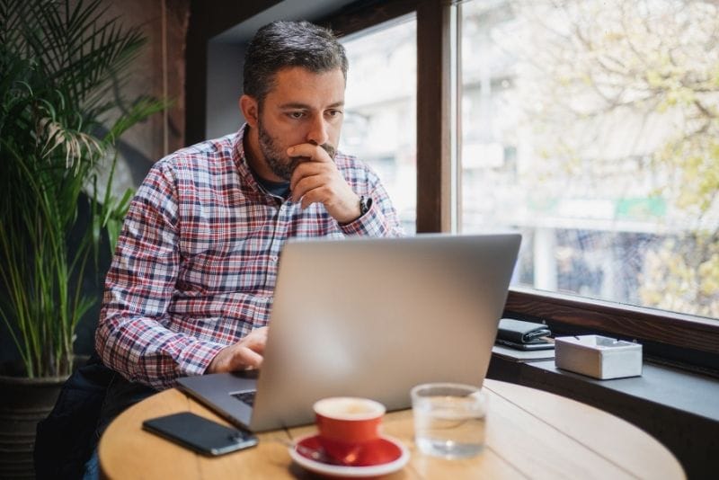 Small business owner working on a laptop inside a café
