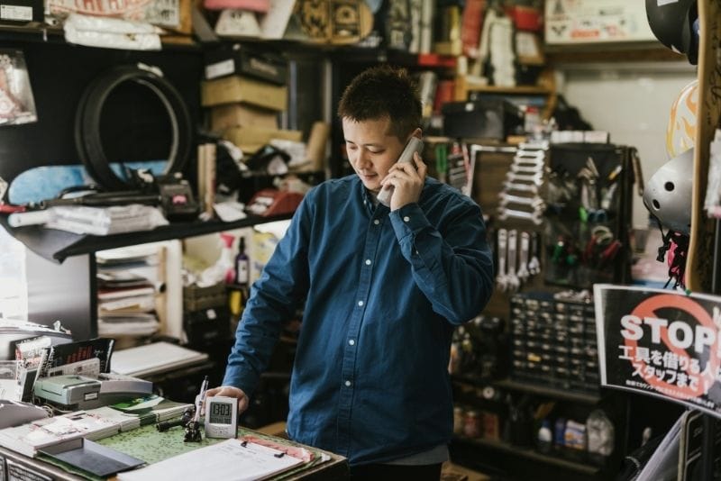 Local business owner speaking on the phone inside a shop