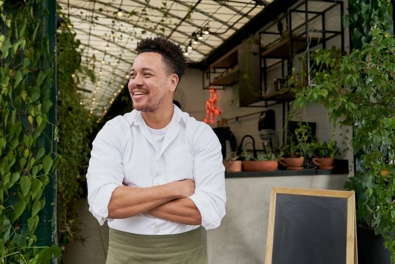 Small restaurant owner standing outside his local business